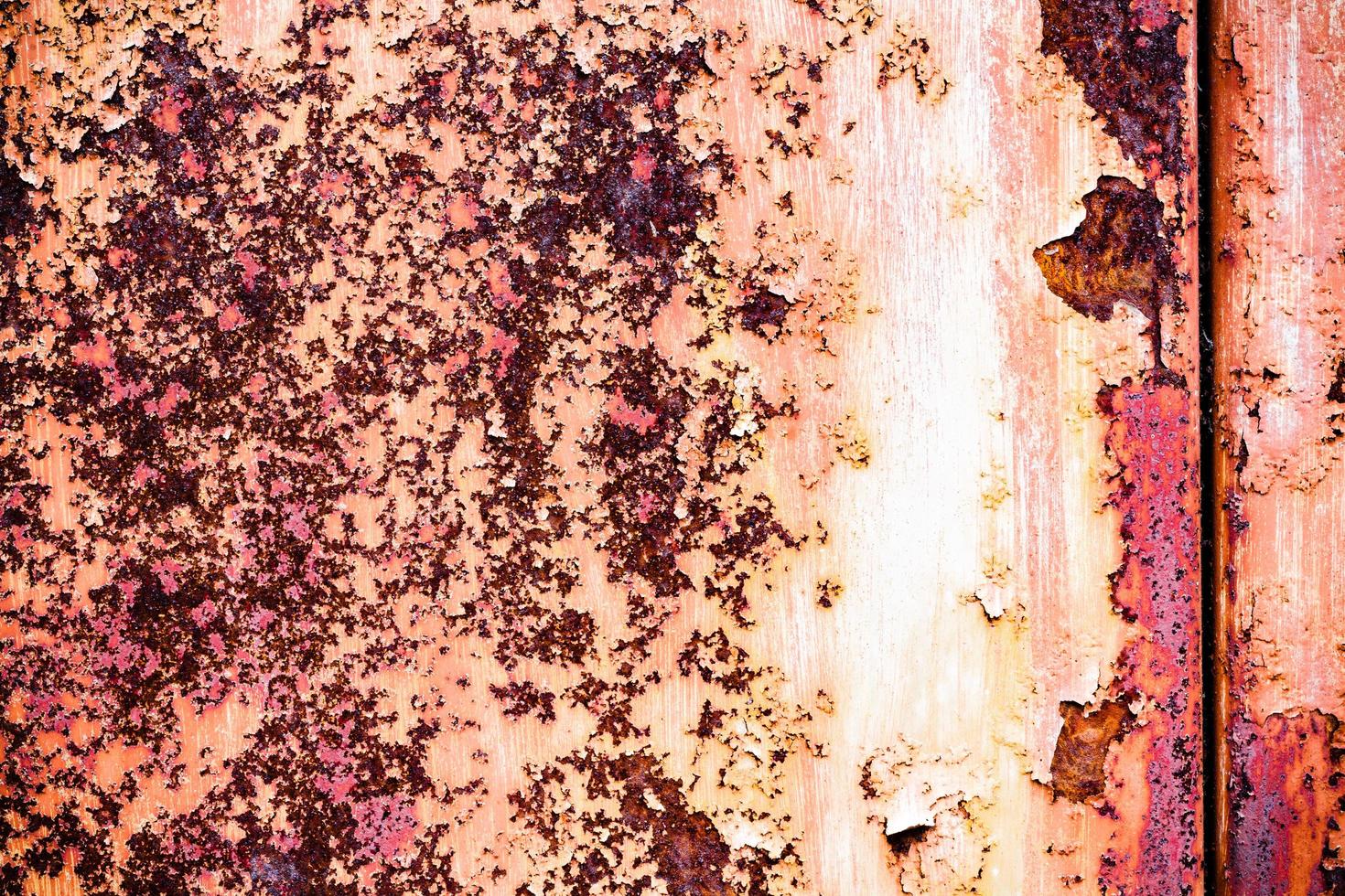 Brown grunge texture of an old metal wall covered in rust. Textured surface with an interesting pattern, dirty sheet metal with peeling paint. Weathered, rough and rust-eaten iron wall of the garage. photo