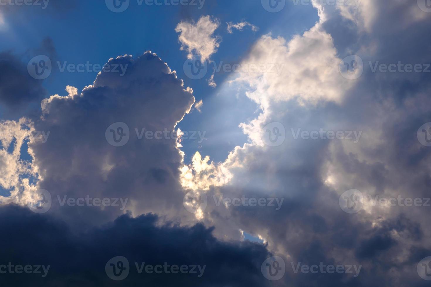 rayos de sol brillante rompiendo hermosas nubes en el cielo azul foto