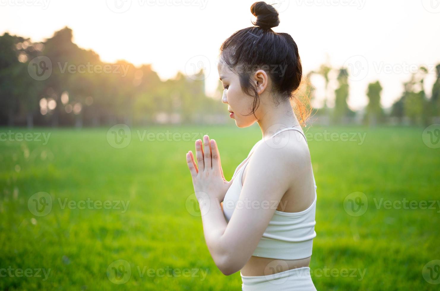 image of asian woman doing yoga outdoors photo