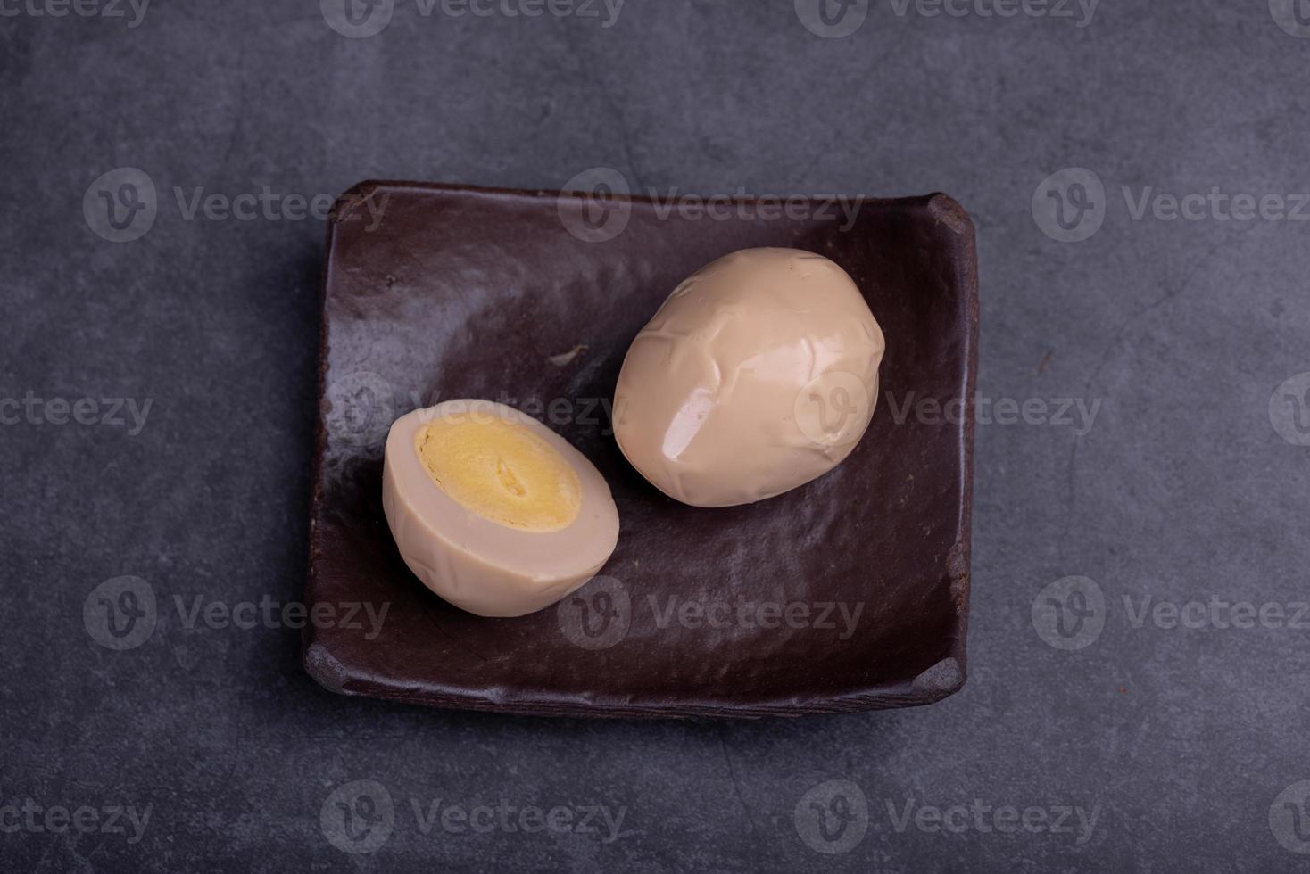 Chinese tea eggs, cut or whole marinated eggs in dark background