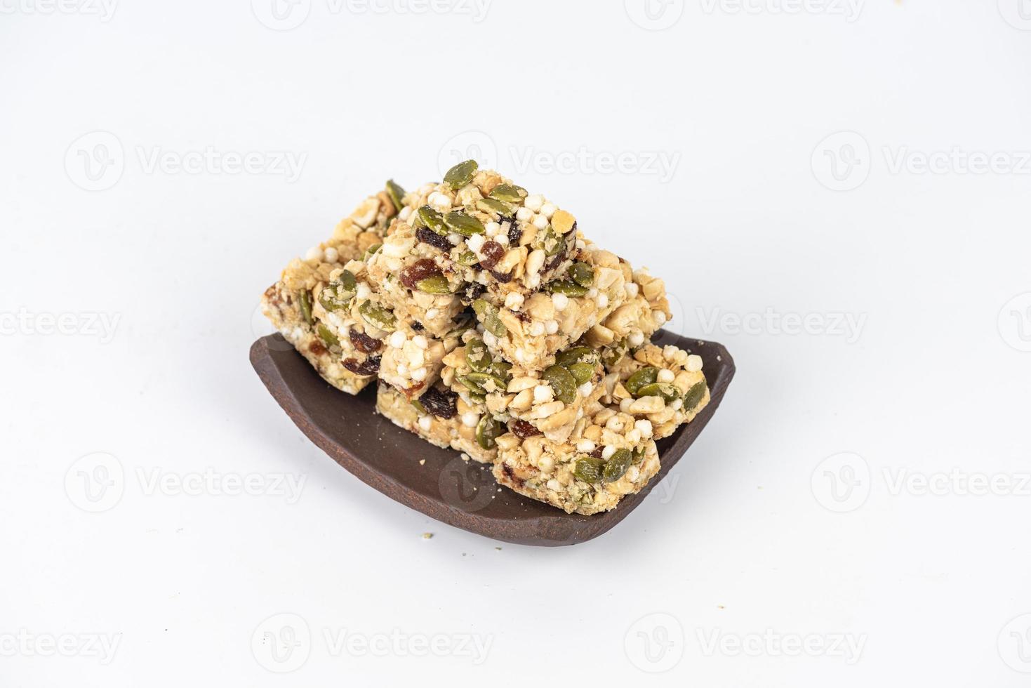 Desserts made of peanuts, melon seeds, raisins, cashews and walnuts are on a white background photo