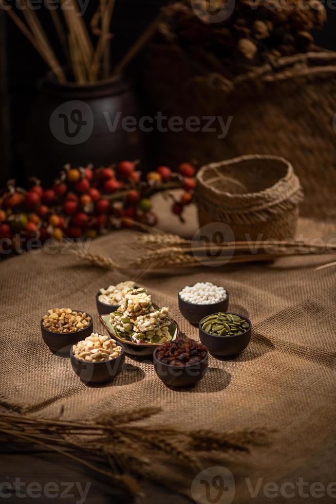 Peanuts, melon seeds, raisins, cashews and walnuts form a geometric shape in a dark background photo