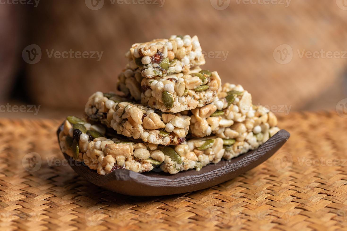 Postres hechos de maní, semillas de melón, pasas, anacardos y nueces están en la mesa de madera. foto