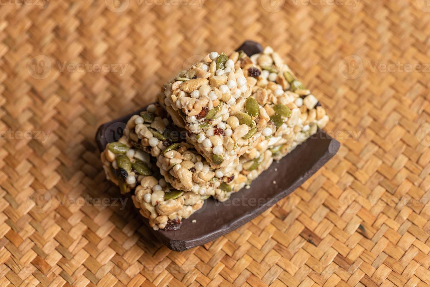 Postres hechos de maní, semillas de melón, pasas, anacardos y nueces están en la mesa de madera. foto