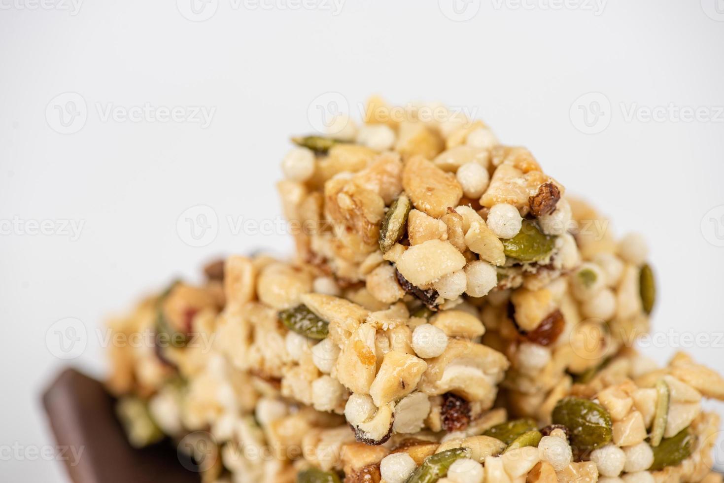 Postres hechos de cacahuetes, semillas de melón, pasas, anacardos y nueces están sobre un fondo blanco. foto