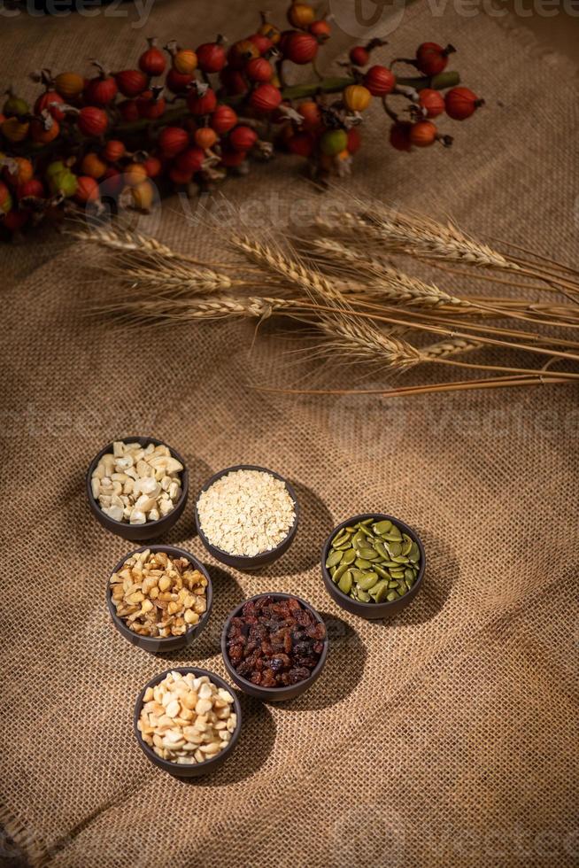 cacahuetes, semillas de melón, pasas, anacardos y nueces forman una forma geométrica sobre un fondo oscuro foto