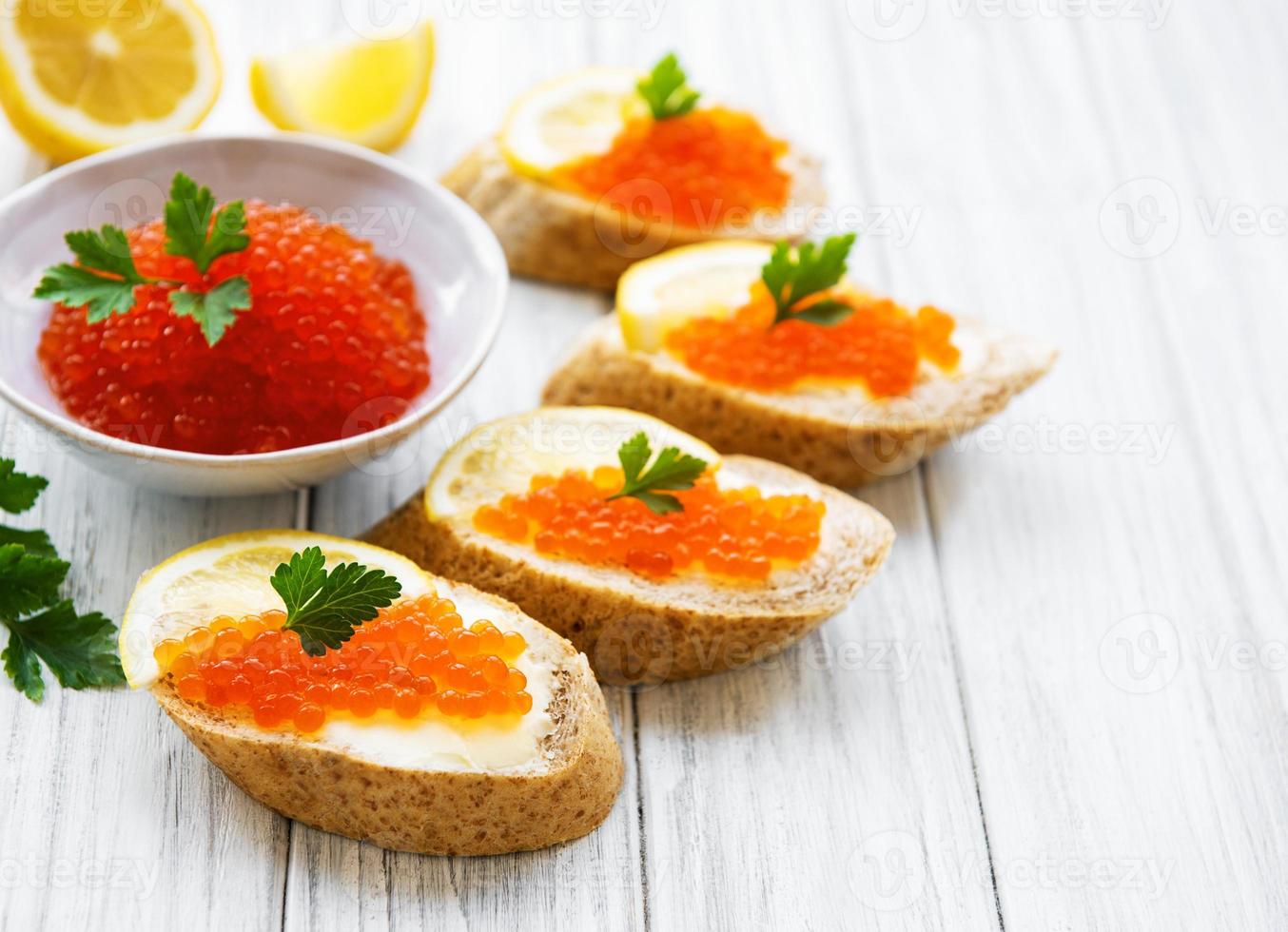 Red caviar in bowl and sandwiches photo