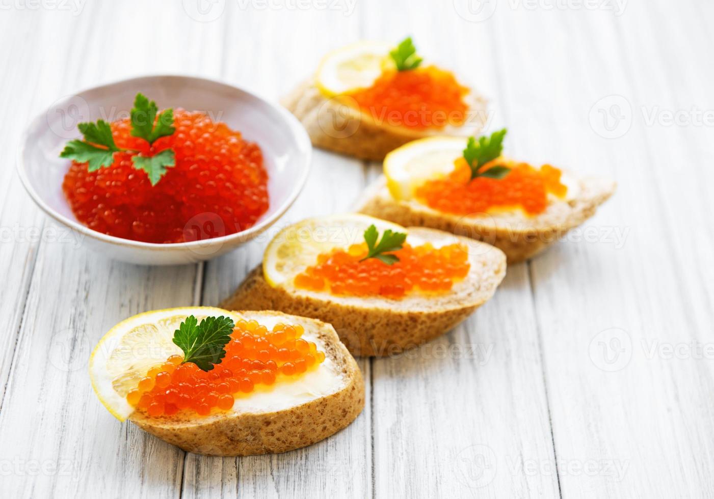 Red caviar in bowl and sandwiches photo