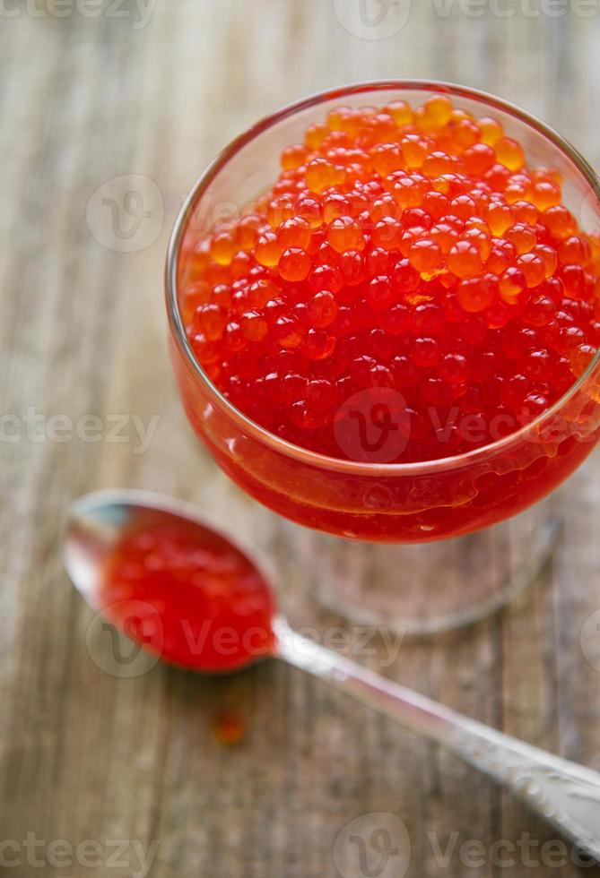 Glass with delicious red caviar photo