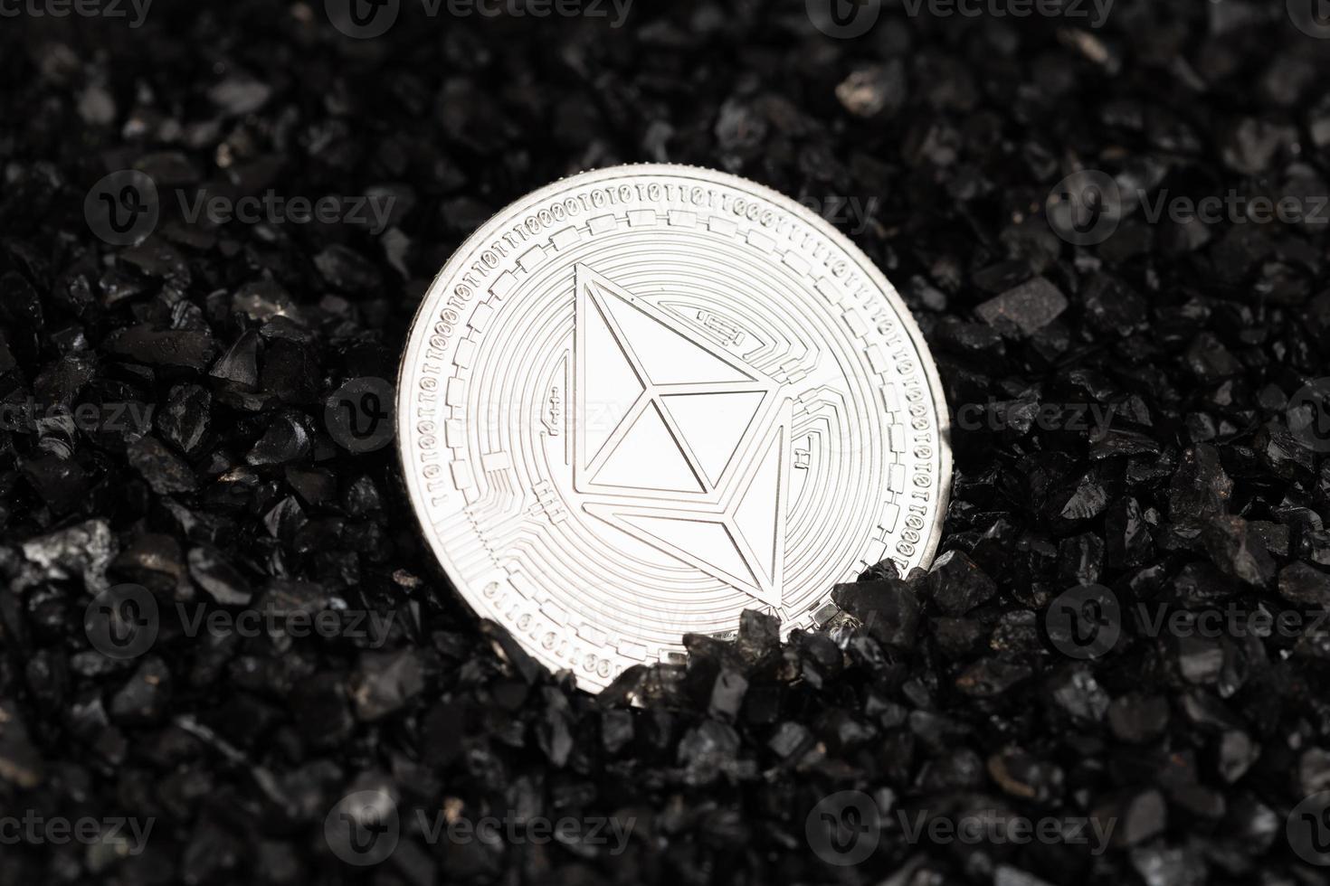 Ethereum coin on black gravel background. Cryptocurrency blockchain money photo