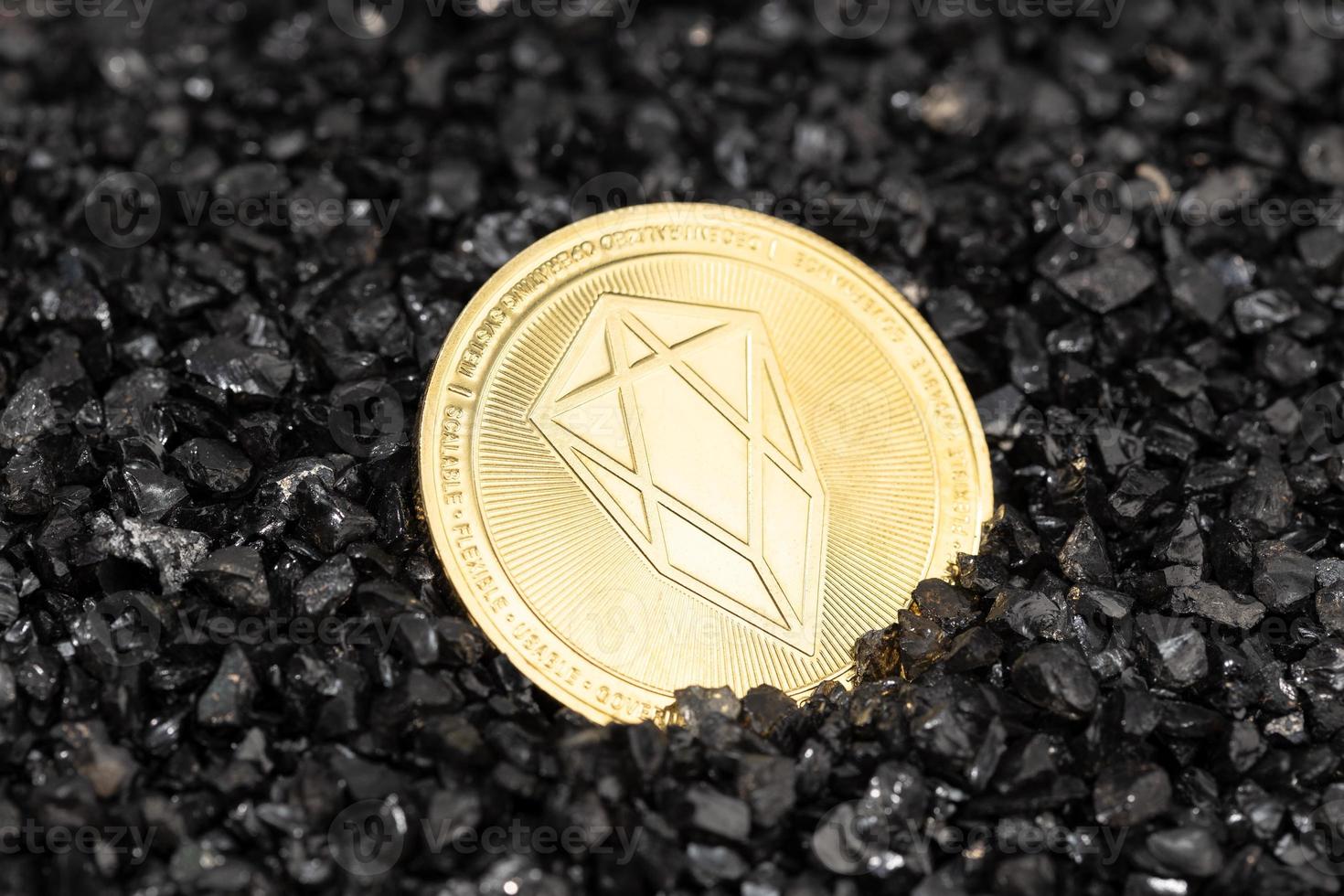 EOS coin on black gravel background. Cryptocurrency blockchain money photo