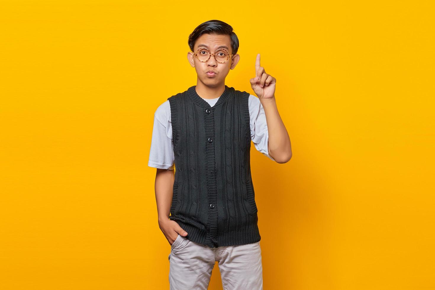 Excited handsome young man raising finger and having creative idea on blue background photo