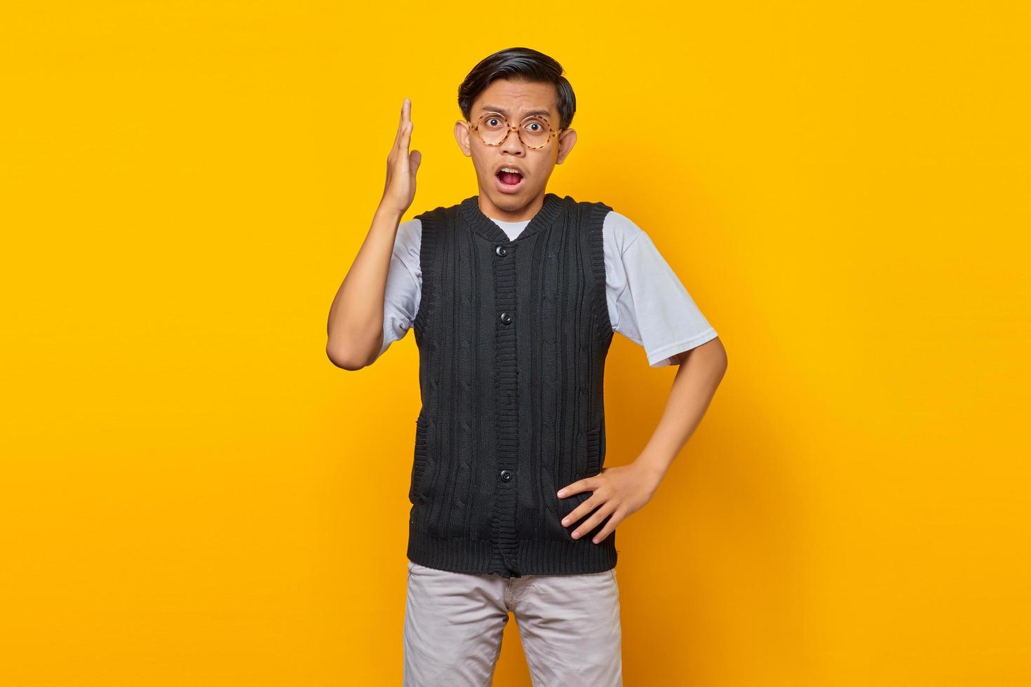 Portrait of unhappy young Asian man having displeased expression and stretching his arms expressing uncertainty photo