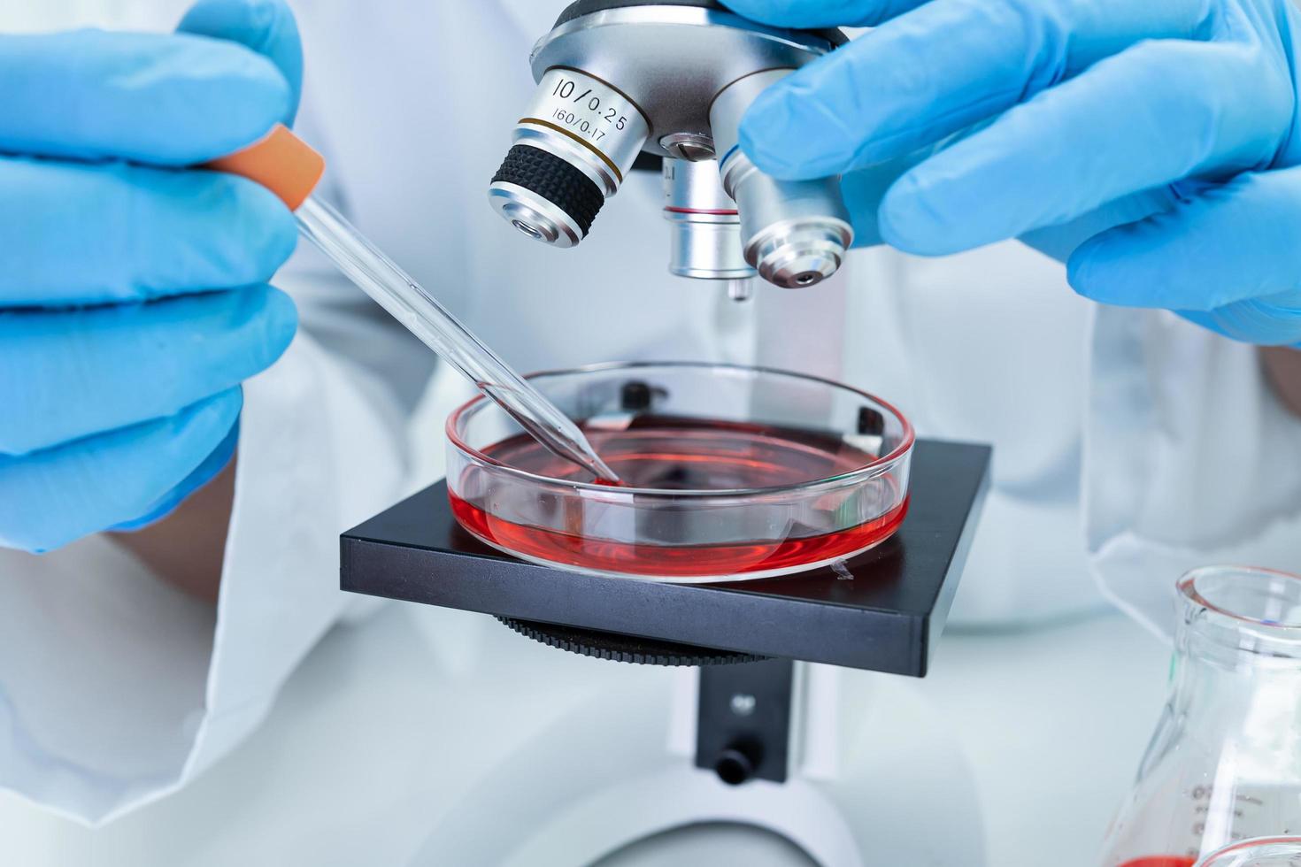 Asian scientist biochemist or microbiologist working research with a microscope in laboratory. For protect outbreak Coronavirus Covid19, bacteria and germs. photo