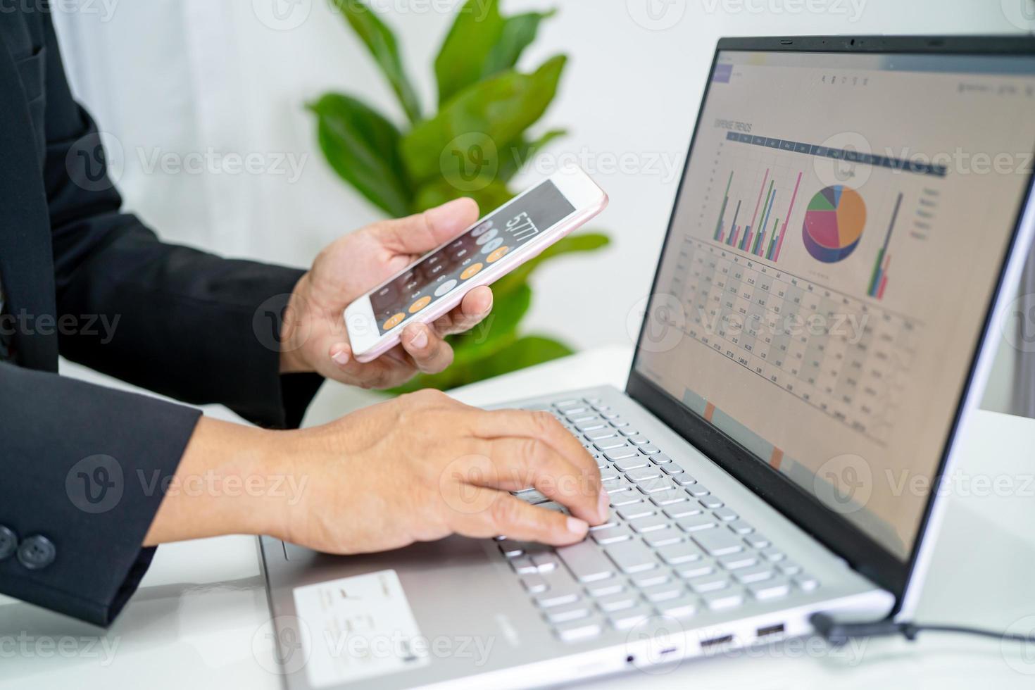 Asian accountant working and analyzing financial reports project accounting with chart graph and calculator in modern office, finance and business concept. photo