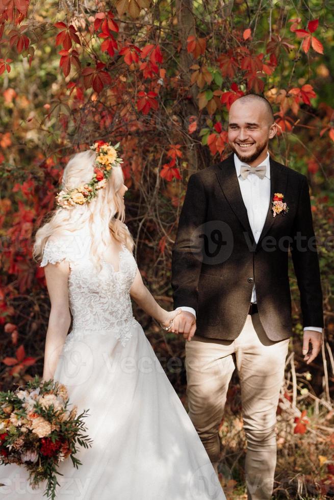 walk of the bride and groom through the autumn forest photo