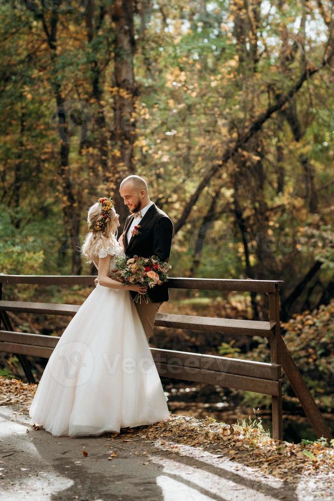 walk of the bride and groom through the autumn forest photo