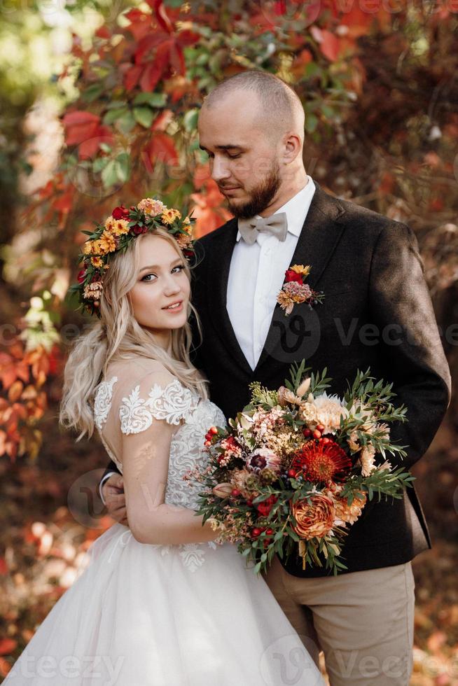 walk of the bride and groom through the autumn forest photo