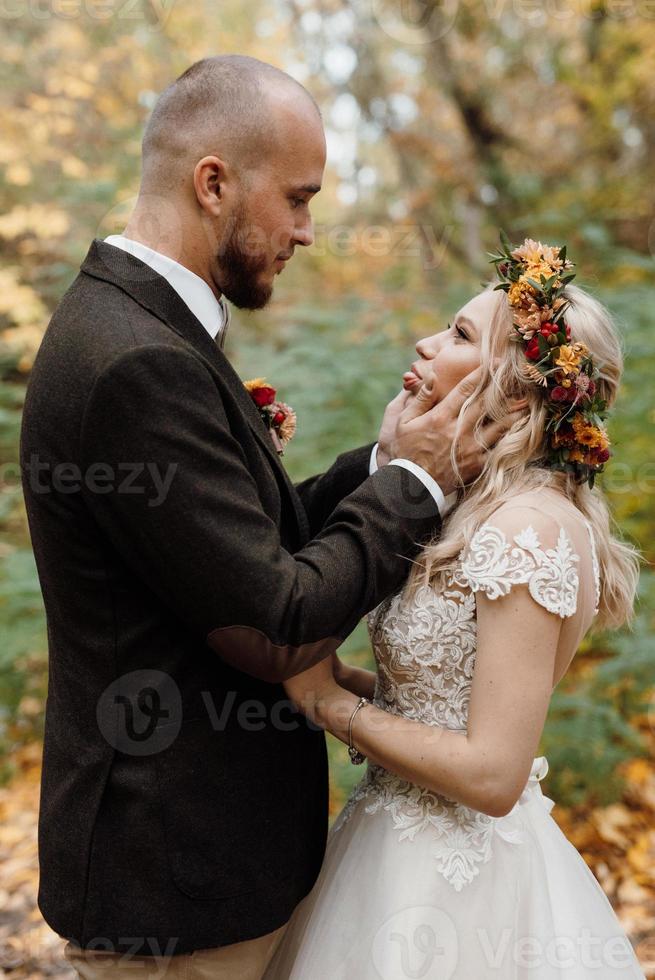 walk of the bride and groom through the autumn forest photo