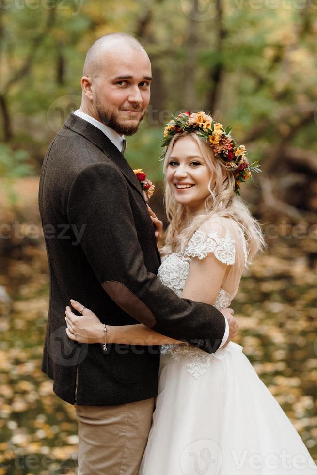 walk of the bride and groom through the autumn forest photo