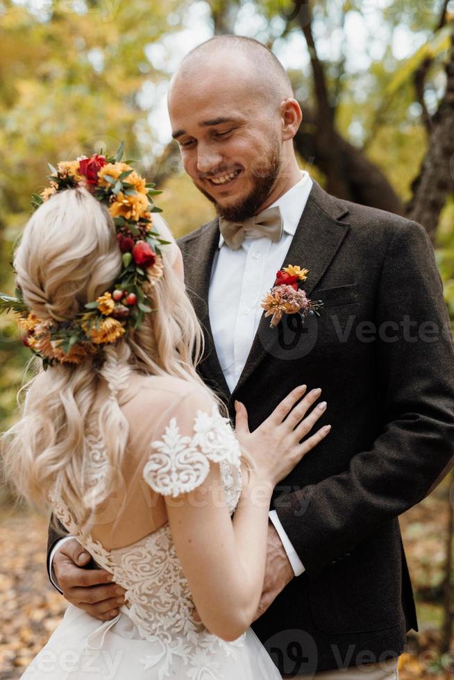 walk of the bride and groom through the autumn forest photo