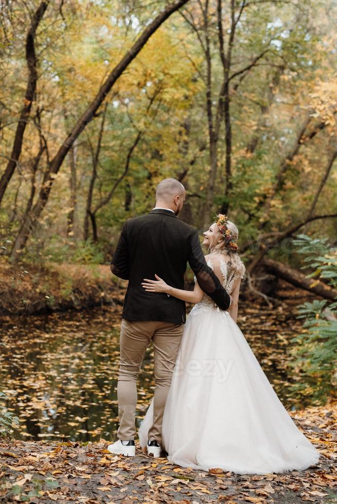 walk of the bride and groom through the autumn forest photo