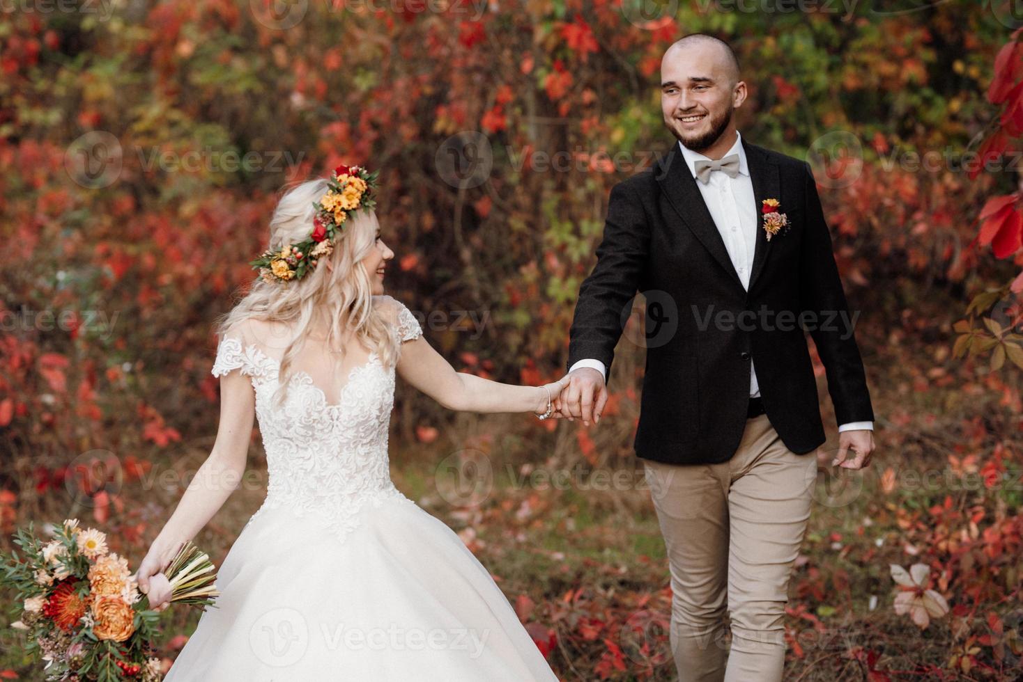 walk of the bride and groom through the autumn forest photo