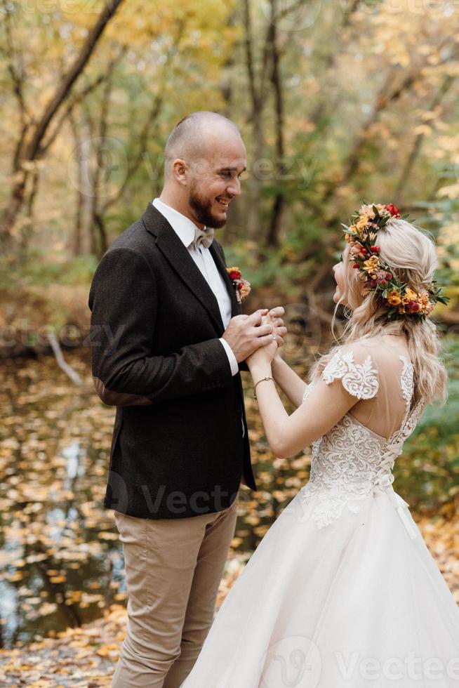 walk of the bride and groom through the autumn forest photo