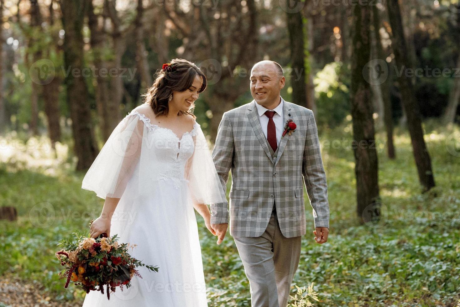 paseo de la novia y el novio por el bosque de otoño foto