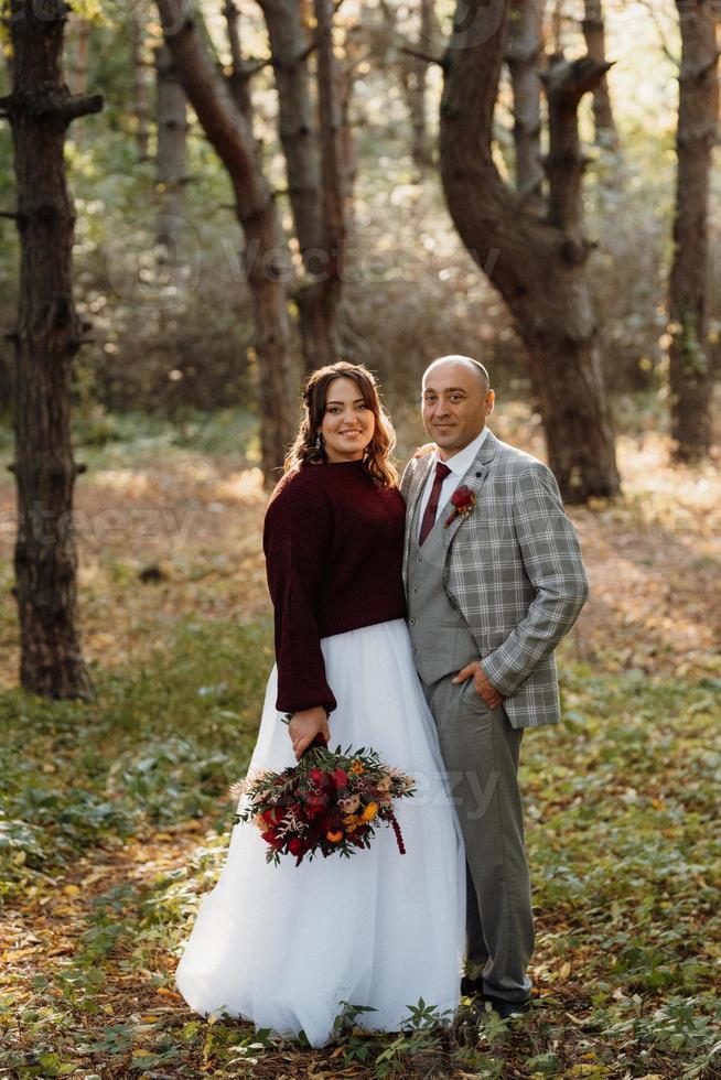 paseo de la novia y el novio por el bosque de otoño foto