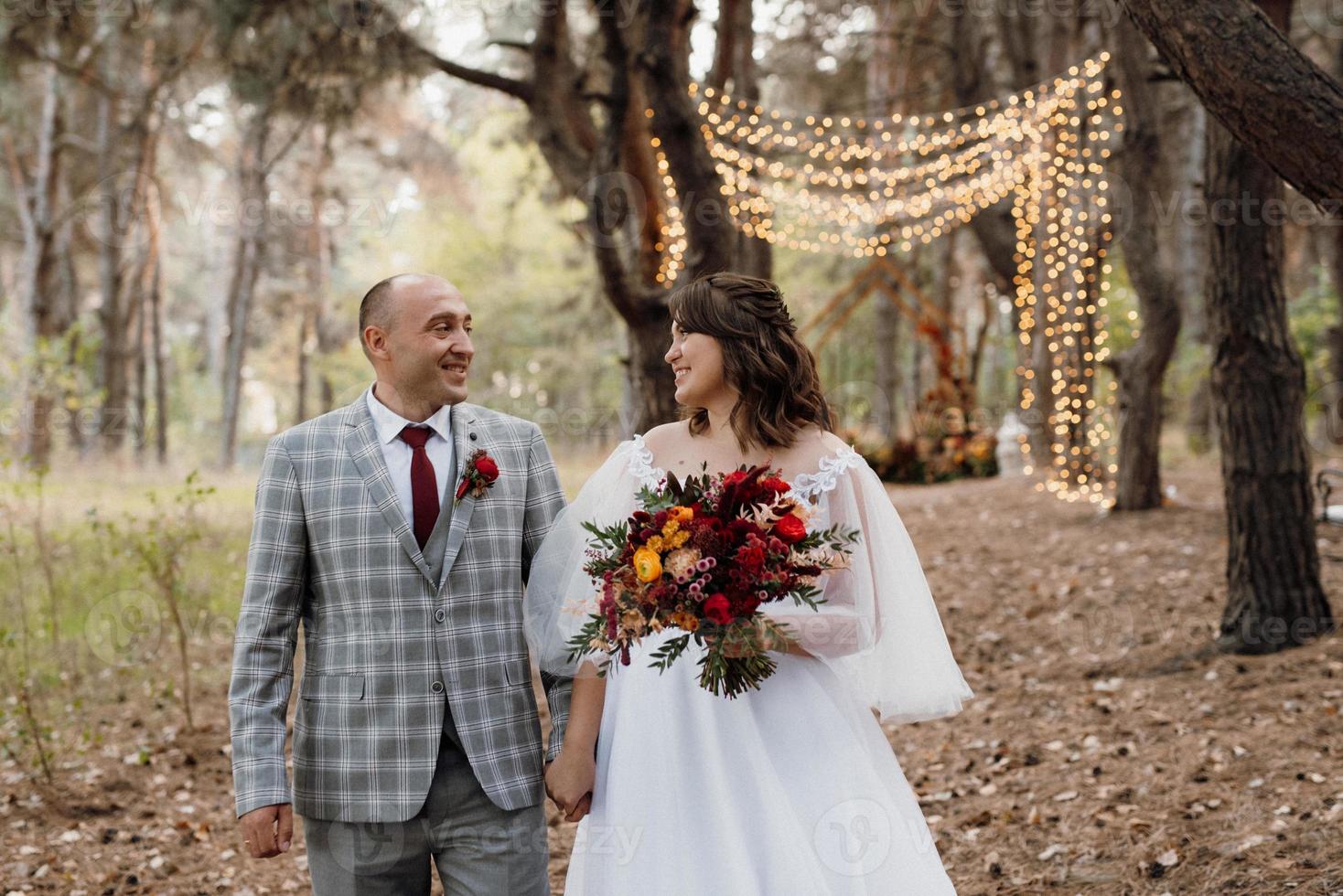 walk of the bride and groom through the autumn forest photo