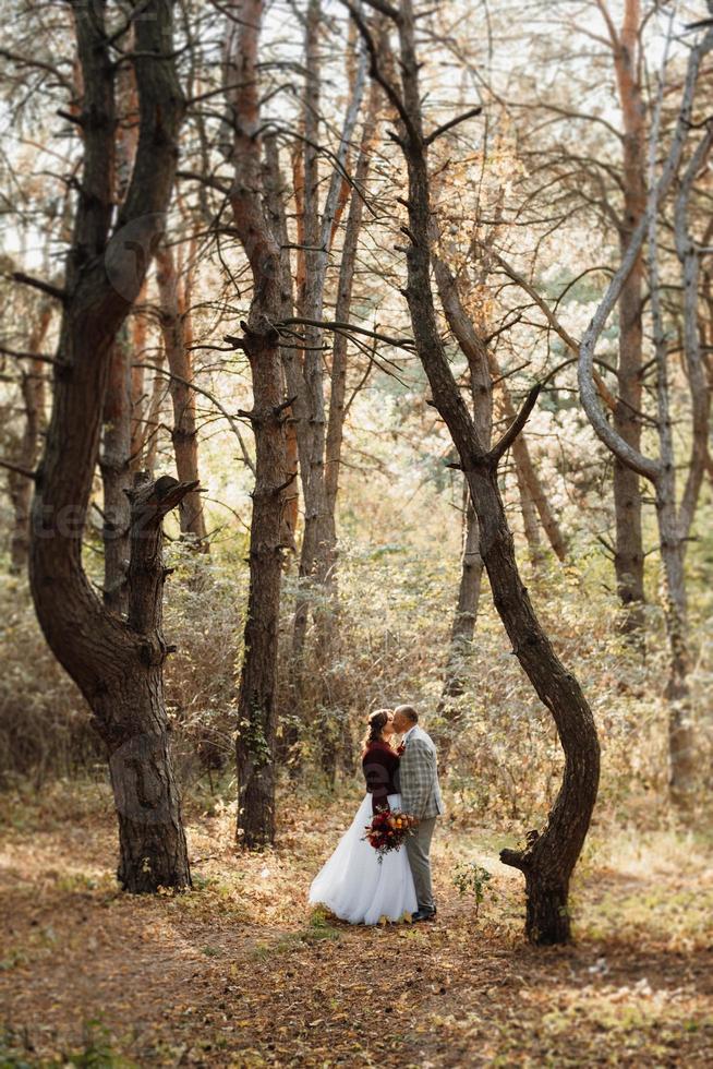 paseo de la novia y el novio por el bosque de otoño foto