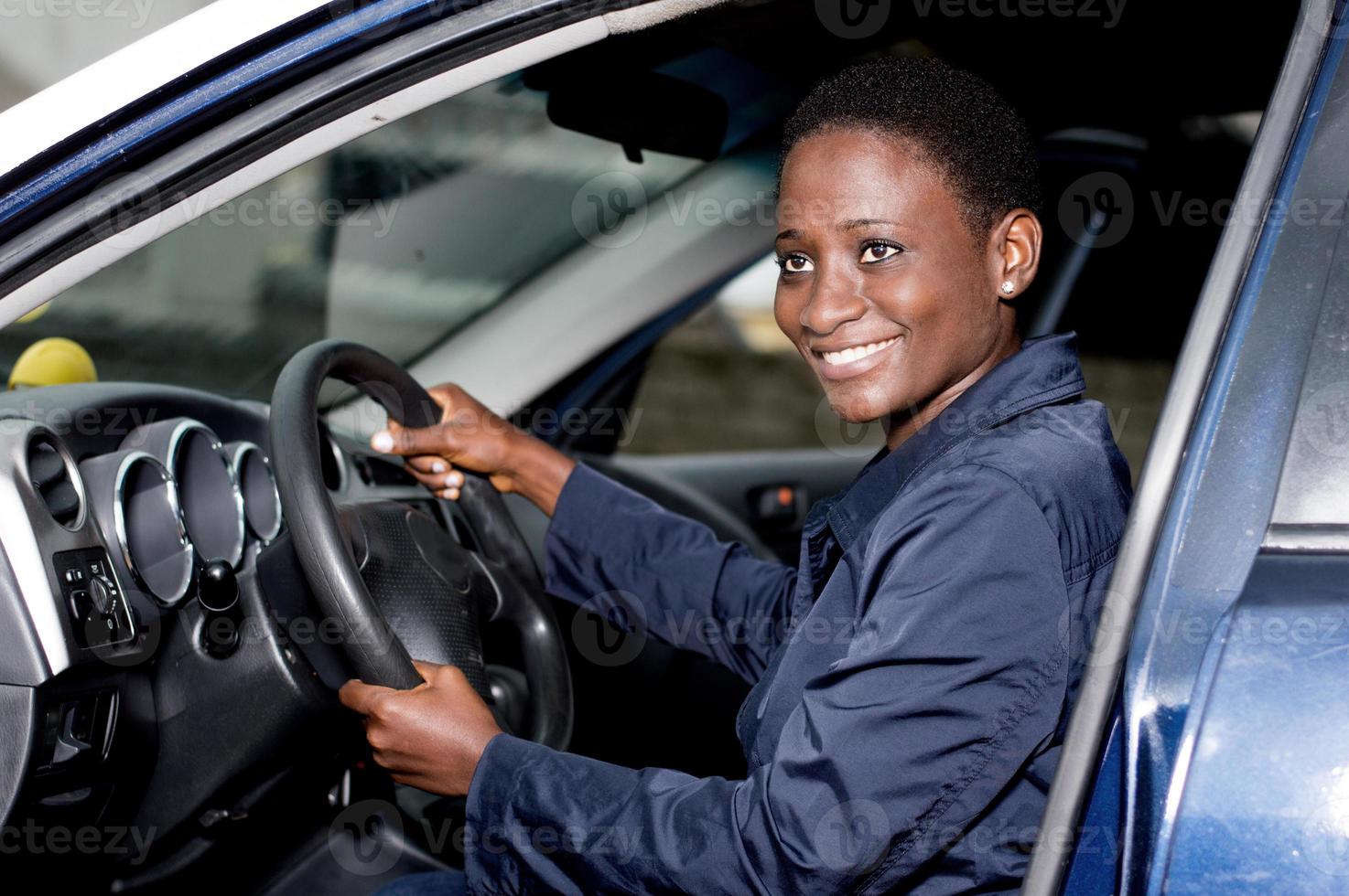 mujer joven sonriendo al volante. foto