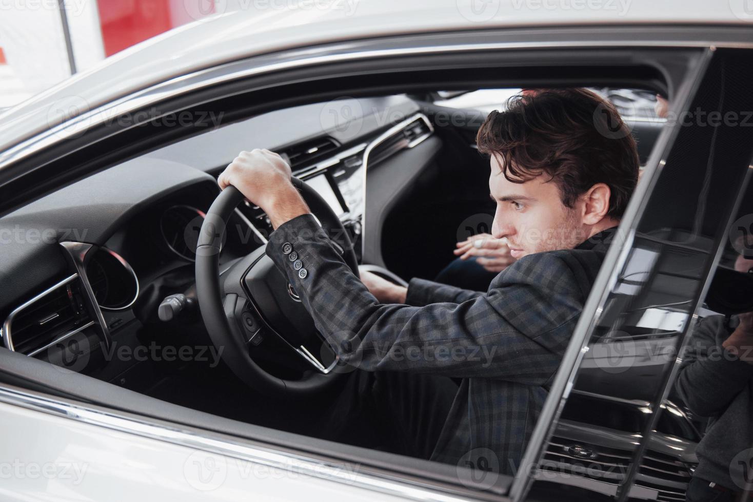 listo para la prueba de manejo. retrato, de, un, guapo, hombre de negocios, conduciendo coche foto