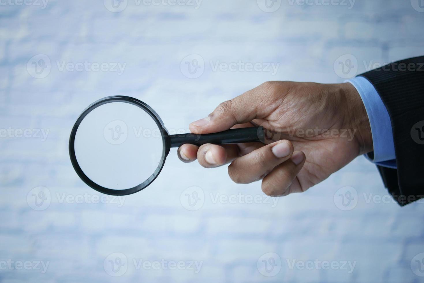 businessmen hand hold a magnifying glass photo