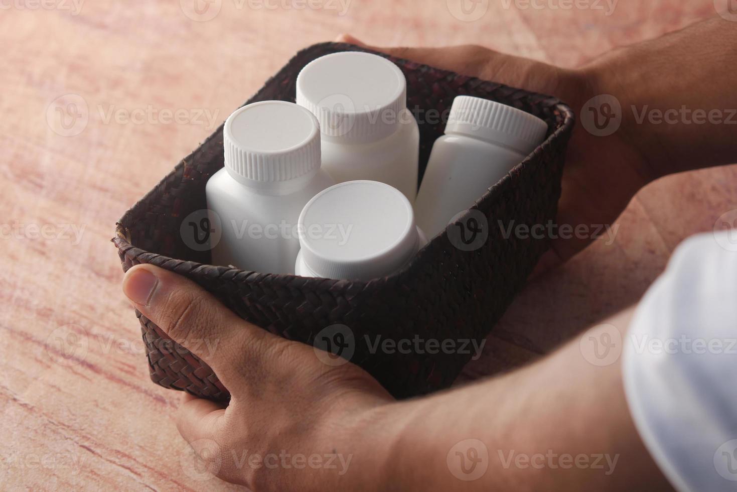 young man hand holding many medicine pill container white sited photo