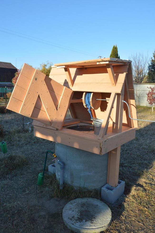 Wooden house for drinking water well photo