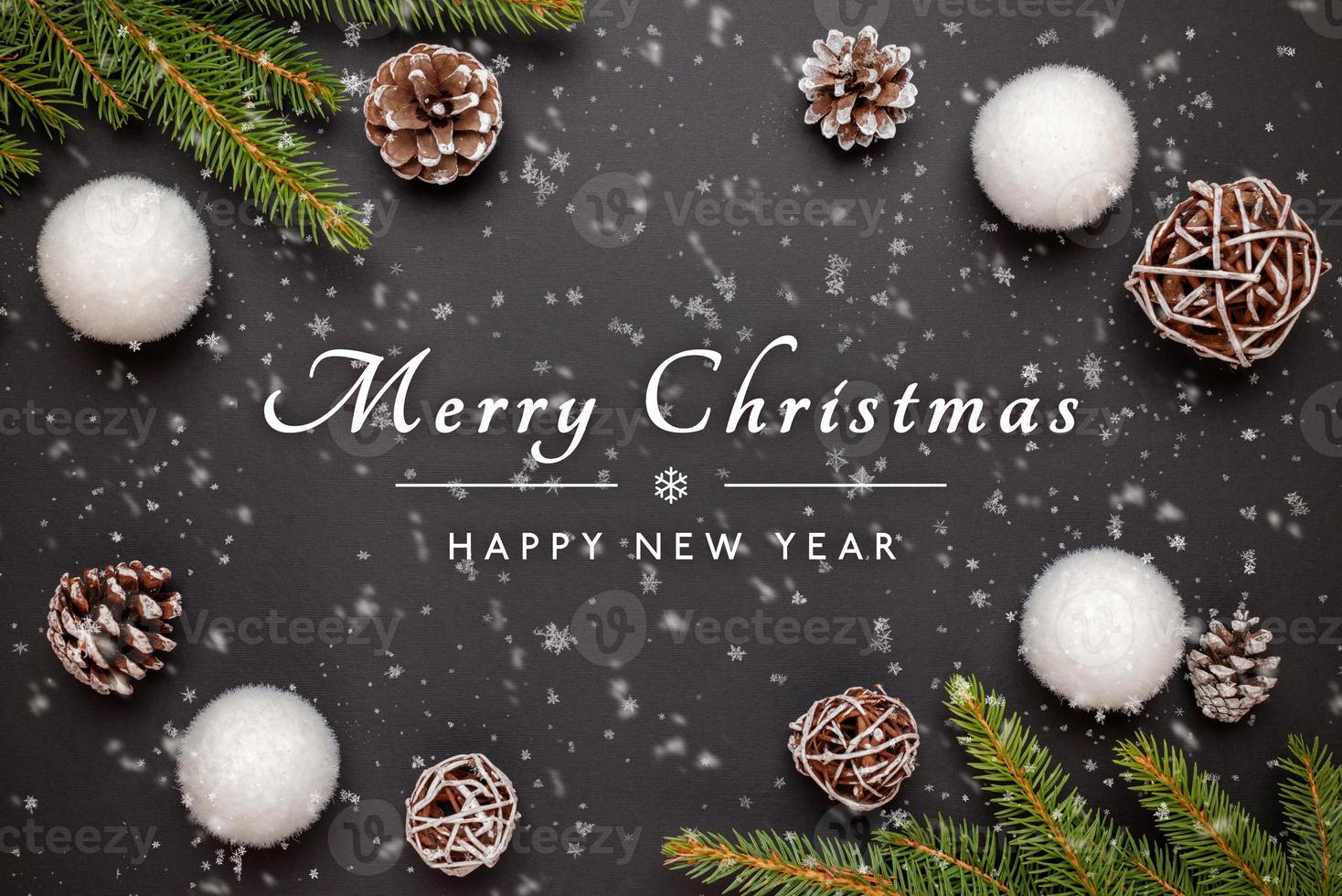 Merry Christmas and Happy New Year greeting card with decorations on black surface photo