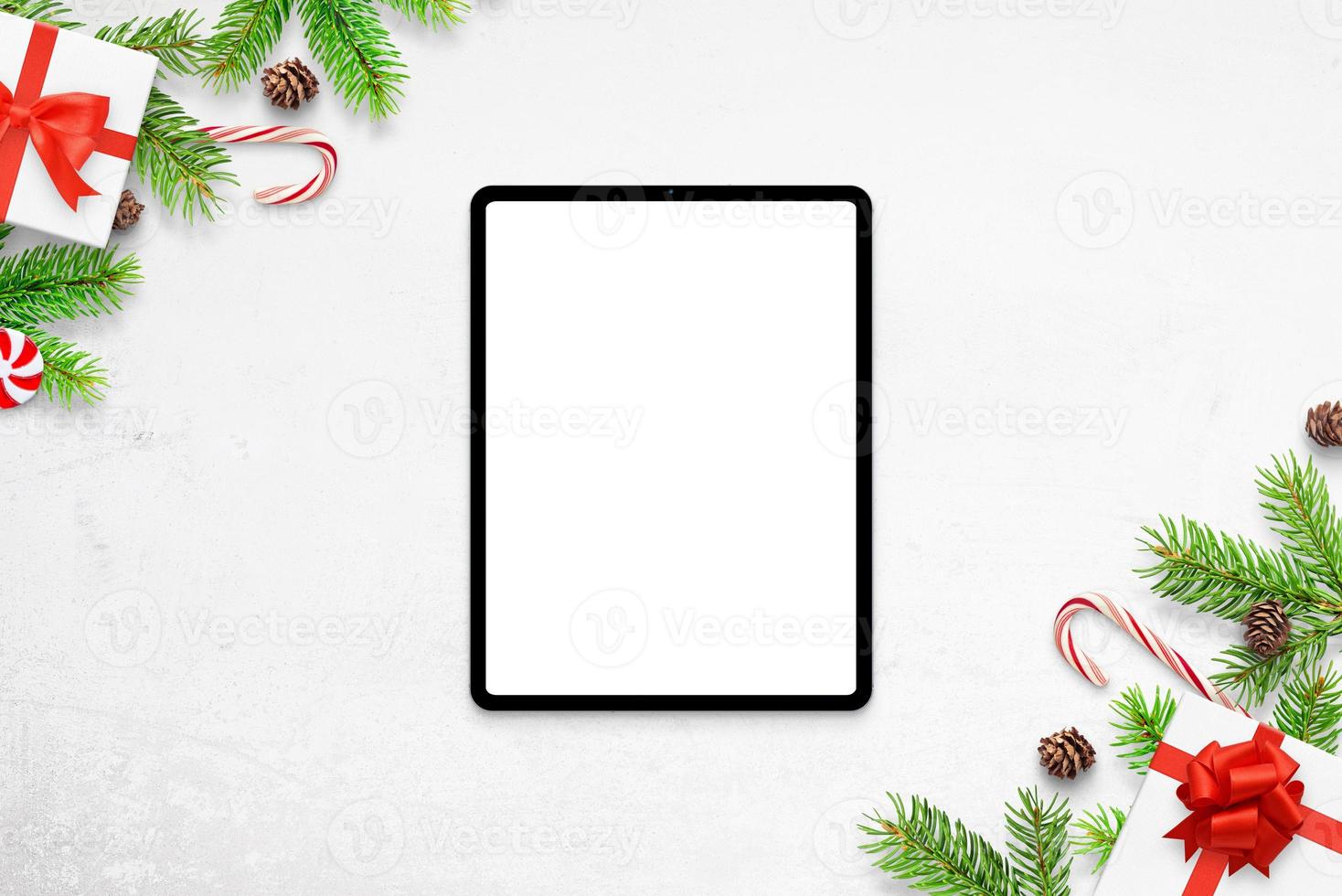 maqueta de tableta en el escritorio blanco con adornos navideños. vista superior, composición plana foto