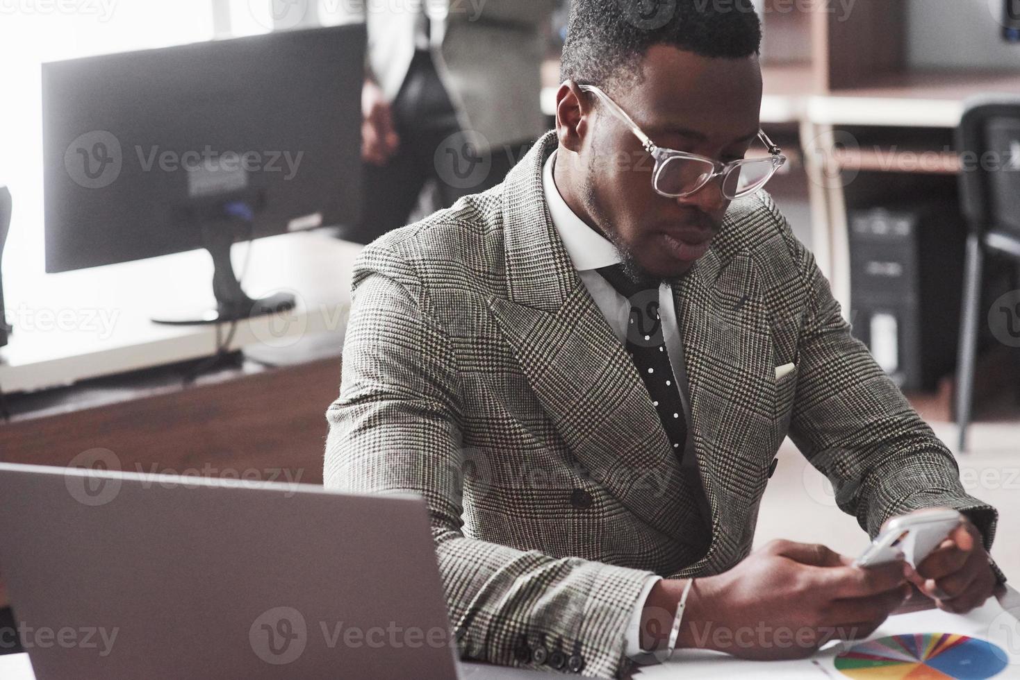 Imagen del empresario afroamericano trabajando en su computadora portátil foto