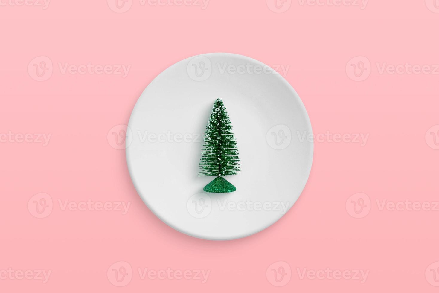 pequeño árbol de navidad en un plato. concepto mínimo de celebración navideña foto