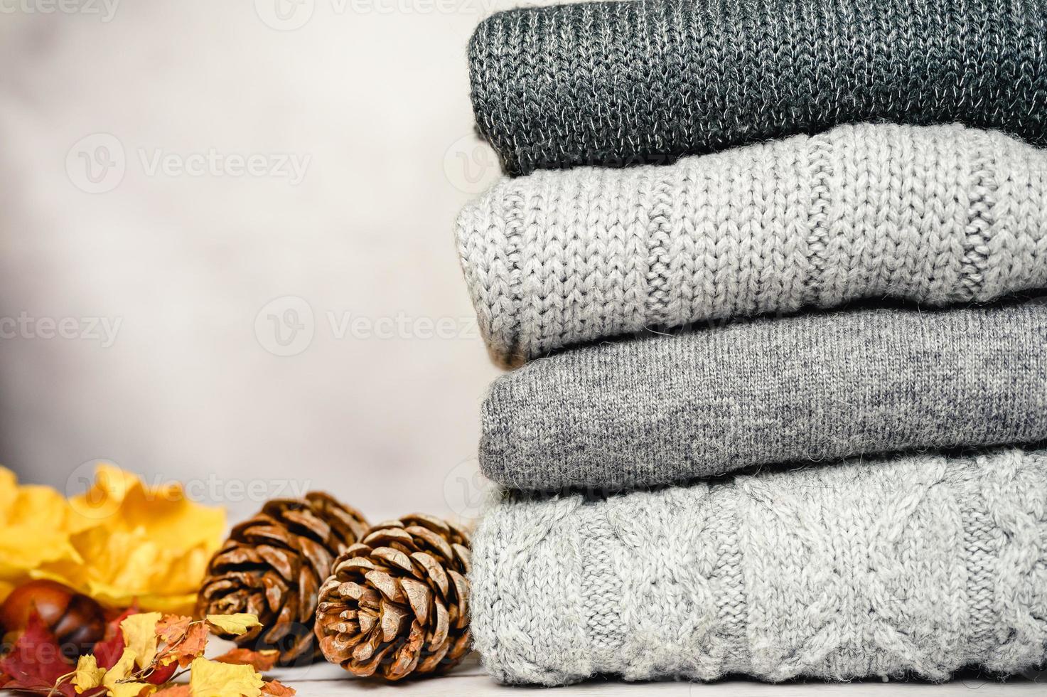 autumn yellow and red maple leaves on the background of gray cozy knitted sweater photo