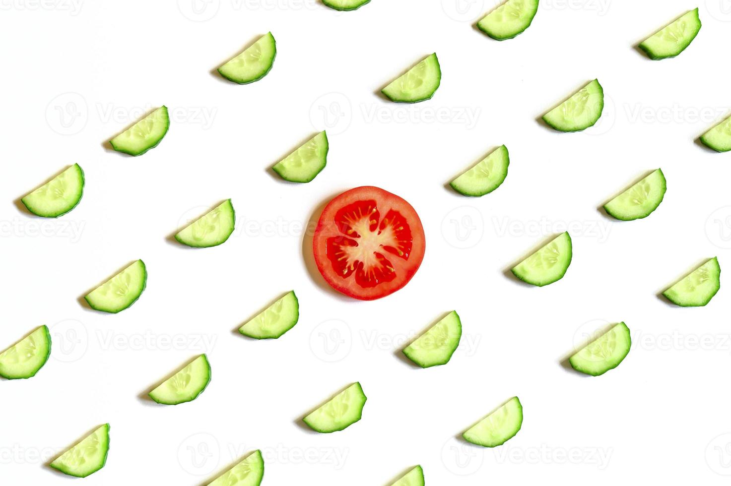 repeating pattern of sliced semicircles of fresh raw vegetable cucumbers for salad and tomato photo