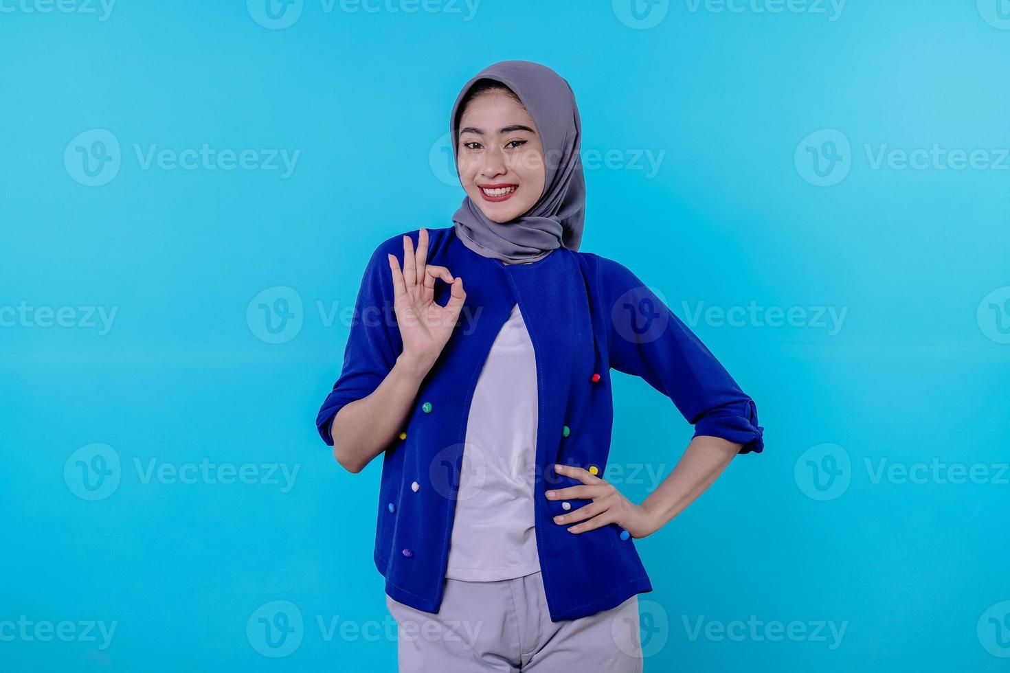 Cheerful woman with wearing hijab showing ok sign photo