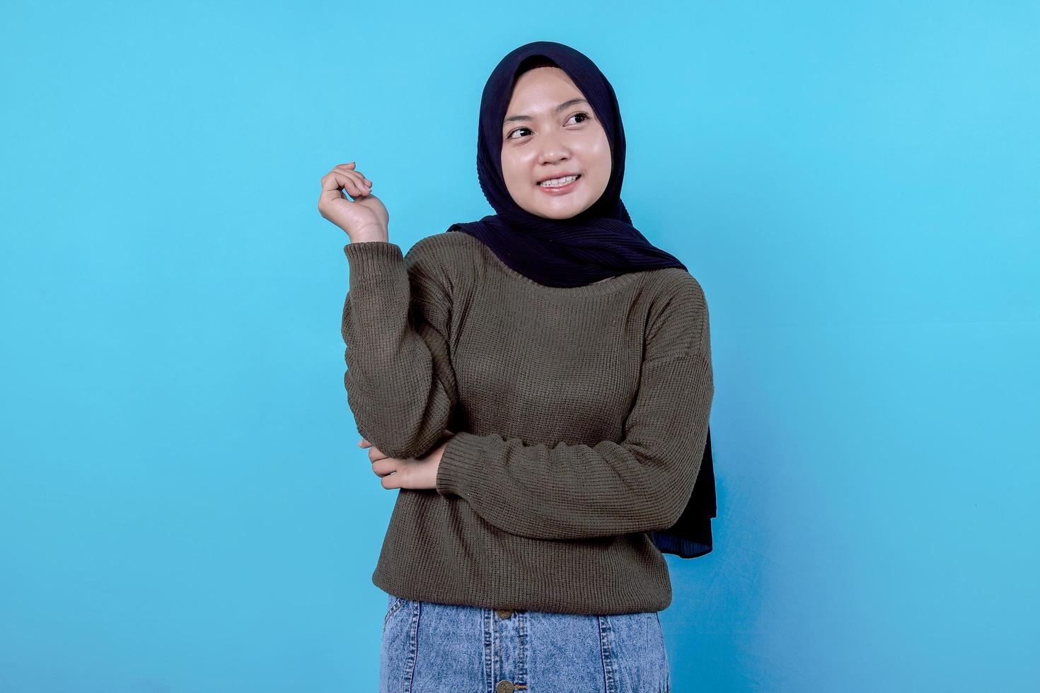 Close-up of happy girl wearing hijab in casual cloth and smiling on blue wall photo