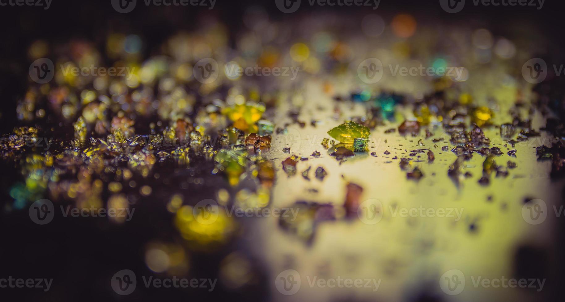 Colored diamonds scattered on a dark surface photo