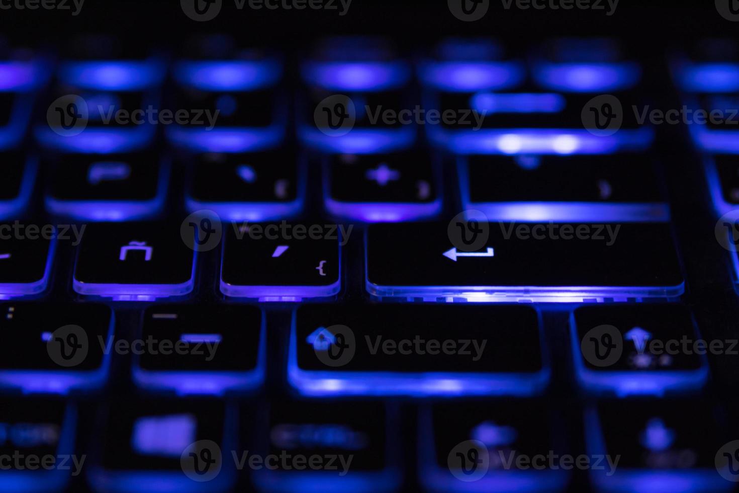 Primer plano de la iluminación del teclado del portátil, teclado retroiluminado. luz azul foto