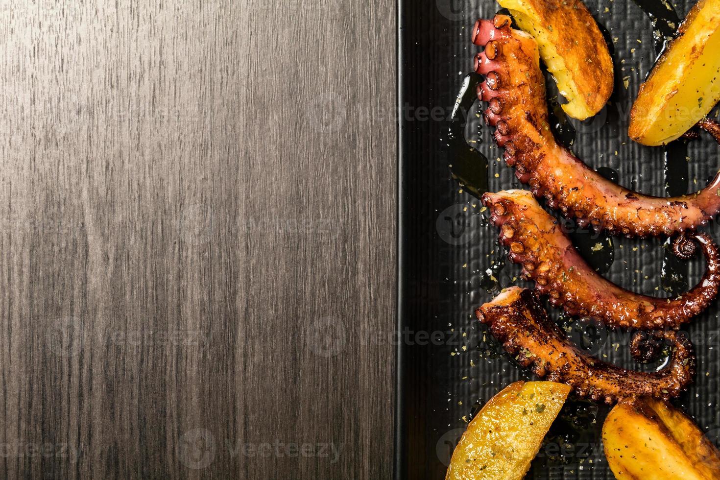 octopus tentacles grilled with potatoes. Copy space photo