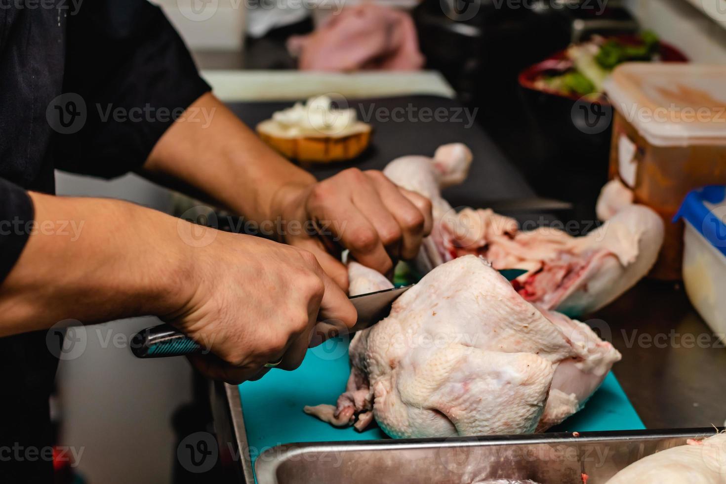 Cerrar chef preparado cortando pechuga de pollo foto