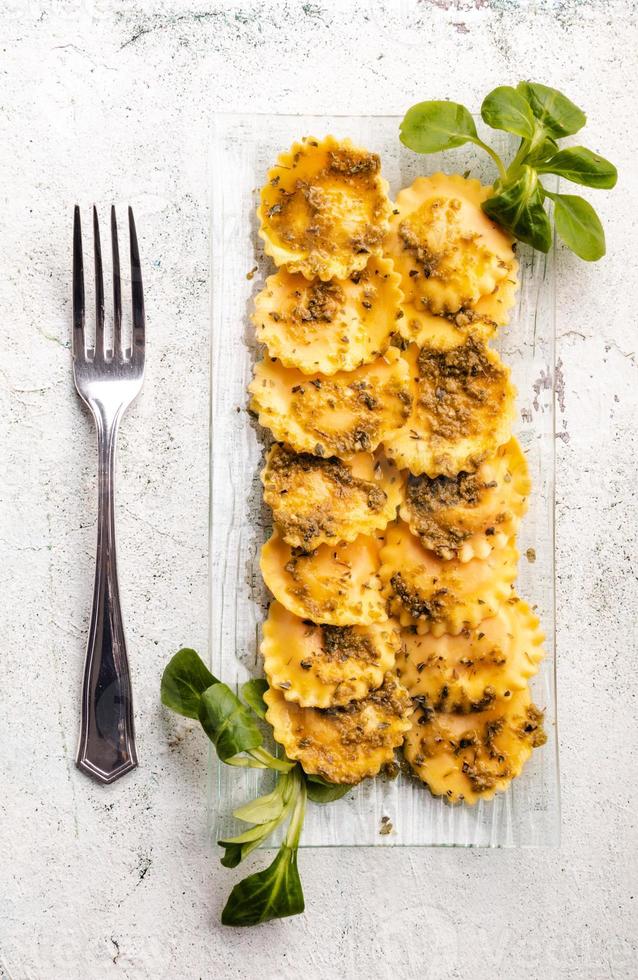 Italian stuffed pasta ravioli with pesto sauce photo